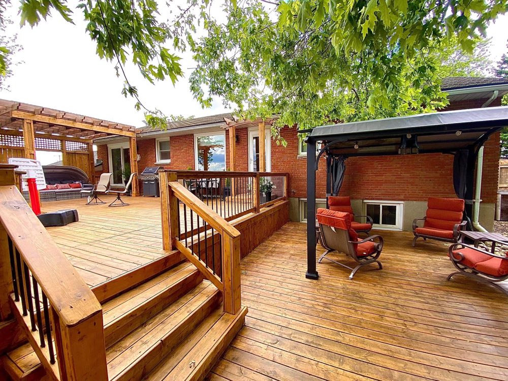 Backyard wood deck and patio seating area with pergola