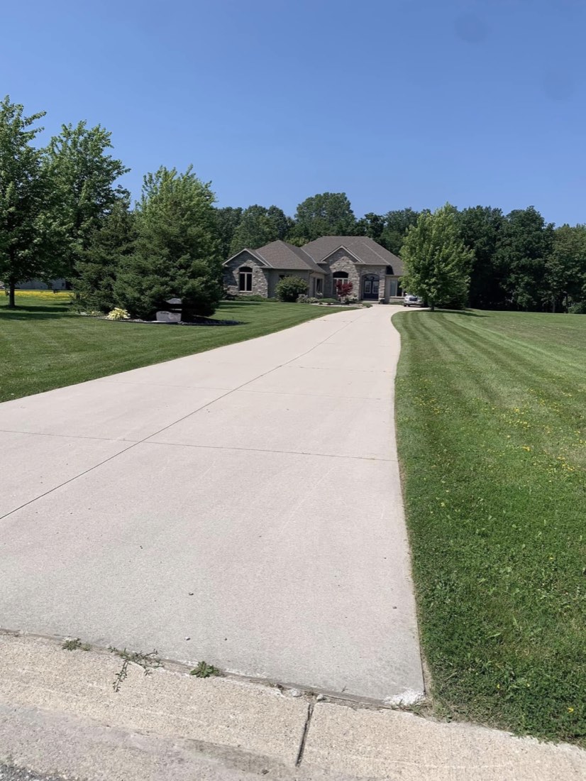 Freshly power-washed driveway leading to a home