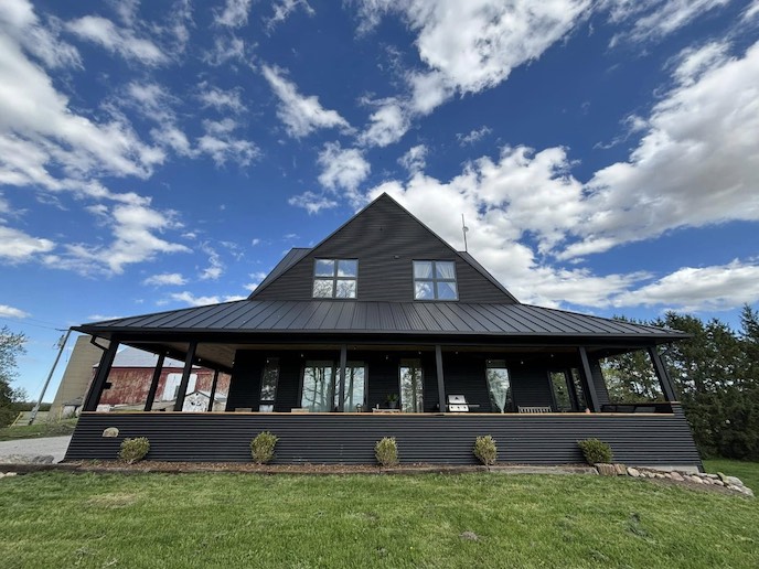Home with dark siding and covered deck after soft washing